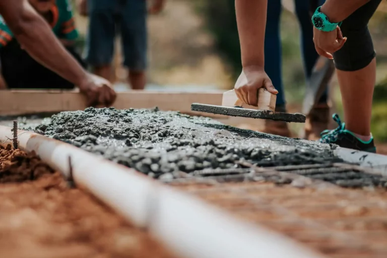 Construção civil com materiais de cimento e tijolos, trabalhador preparando o material para o pagamento de Imposto de Renda.