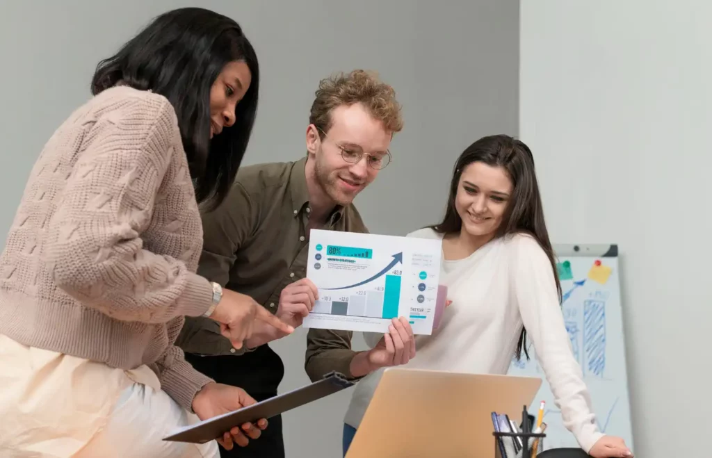 Equipe de profissionais analisando gráficos de dados para aplicar estratégias de marketing na empresa, ilustrando o passo a passo para usar dados no marketing empresarial.