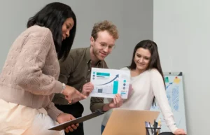 Equipe de profissionais analisando gráficos de dados para aplicar estratégias de marketing na empresa, ilustrando o passo a passo para usar dados no marketing empresarial.