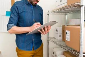 Homem fazendo inventário e avaliando produtos em estoque para definir a estratégia de precificação de seus produtos ou serviços.
