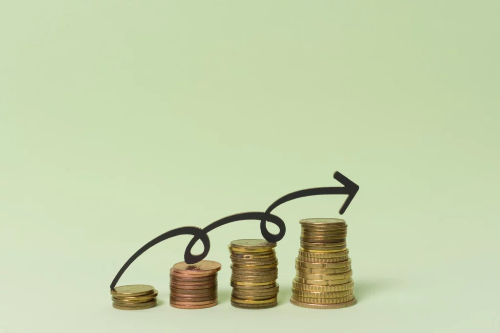 Imagem de pilhas de moedas crescendo de tamanho, representando crescimento financeiro com uma seta indicando aumento no capital de giro para evitar a parada da empresa