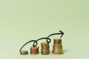 Imagem de pilhas de moedas crescendo de tamanho, representando crescimento financeiro com uma seta indicando aumento no capital de giro para evitar a parada da empresa