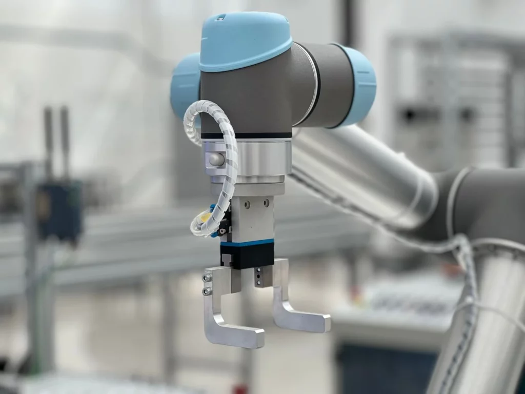Close-up de uma unidade de automação industrial com sensor e atuador em um ambiente de fábrica, com cabos e tubulações ao fundo, ilustrando Automação Industrial e Emprego: O Que os Dados Reais Mostram no Brasil.