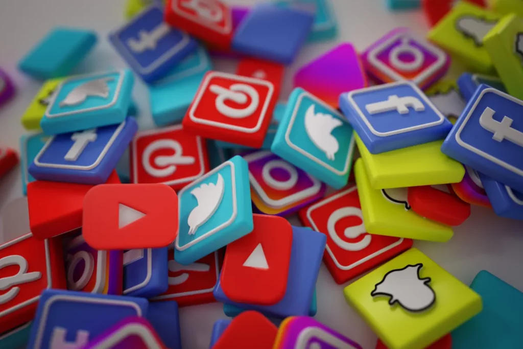 SEO, Redes Sociais ou Anúncios: Onde pequenas empresas devem investir: Coleção de ícones e logos de redes sociais em mini cartões coloridos, incluindo símbolos de YouTube, Instagram e Twitter, em fundo desfocado.