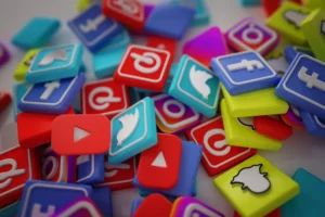 SEO, Redes Sociais ou Anúncios: Onde pequenas empresas devem investir: Coleção de ícones e logos de redes sociais em mini cartões coloridos, incluindo símbolos de YouTube, Instagram e Twitter, em fundo desfocado.